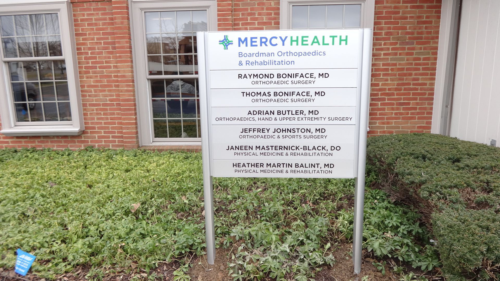 a sign for mercy health is in front of a brick building 