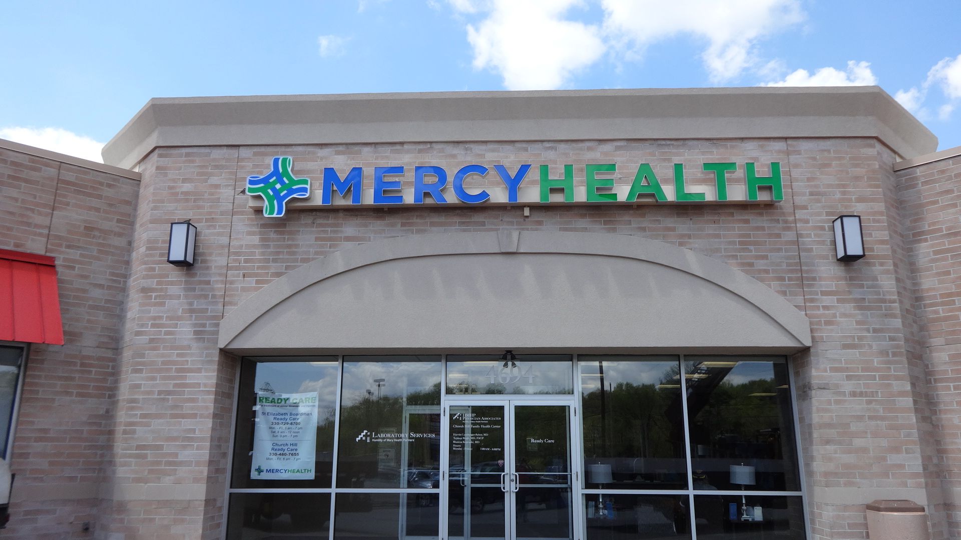 the front of a mercy health store with a red awning