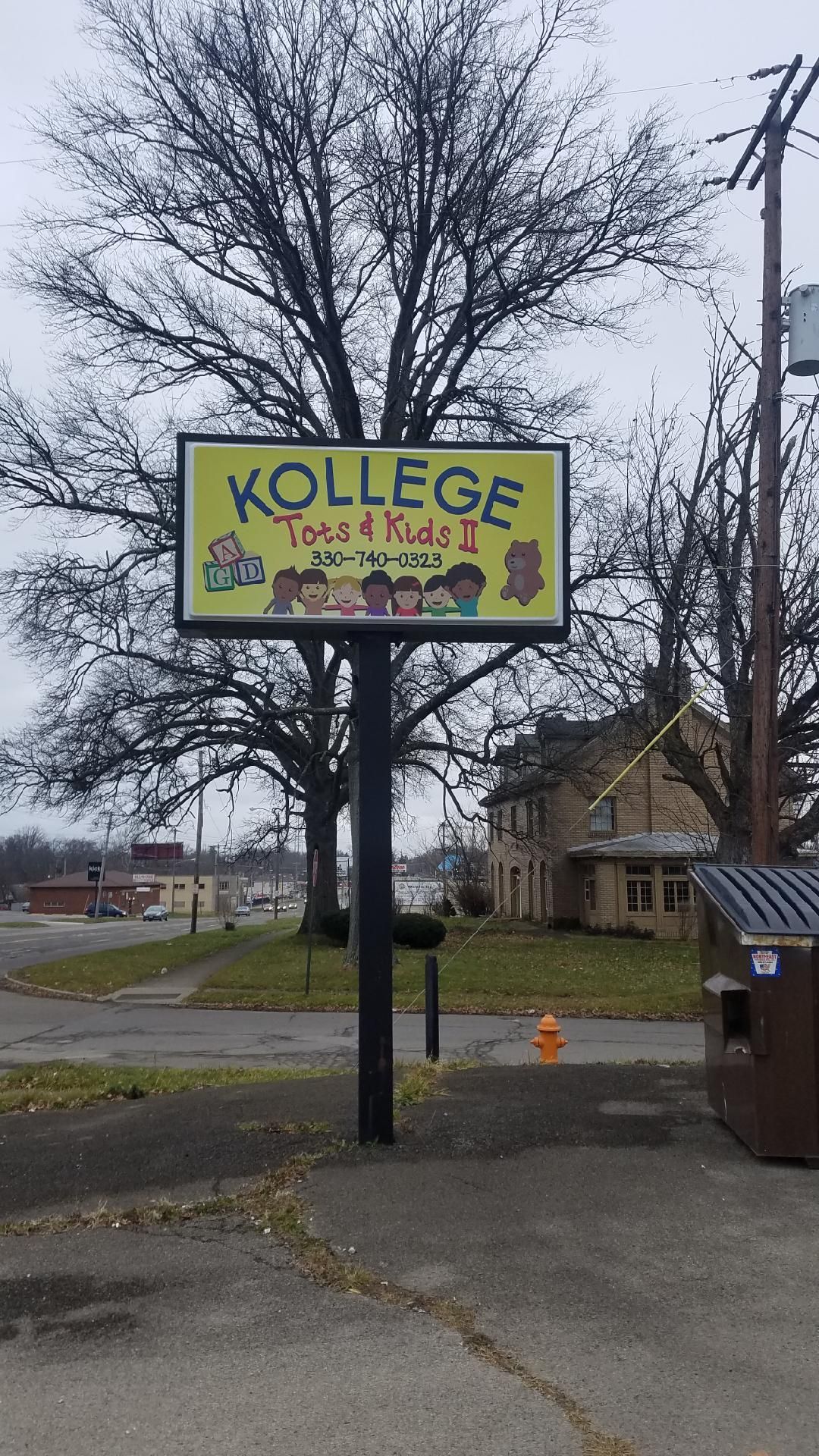 a yellow sign that says ' kollege ' on it in front of a tree 