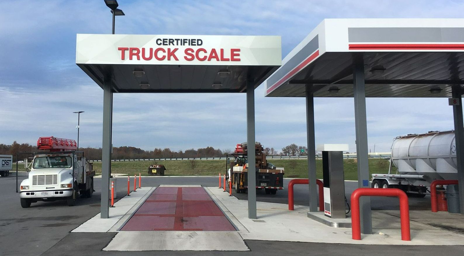 a truck scale in a parking lot next to a gas station