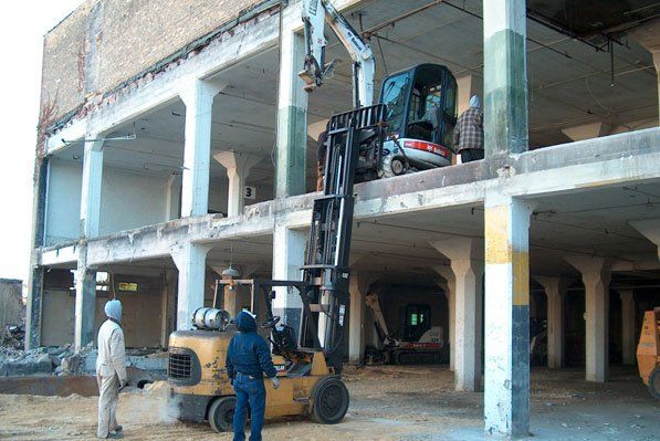 truck lifting another truck on second floor construction