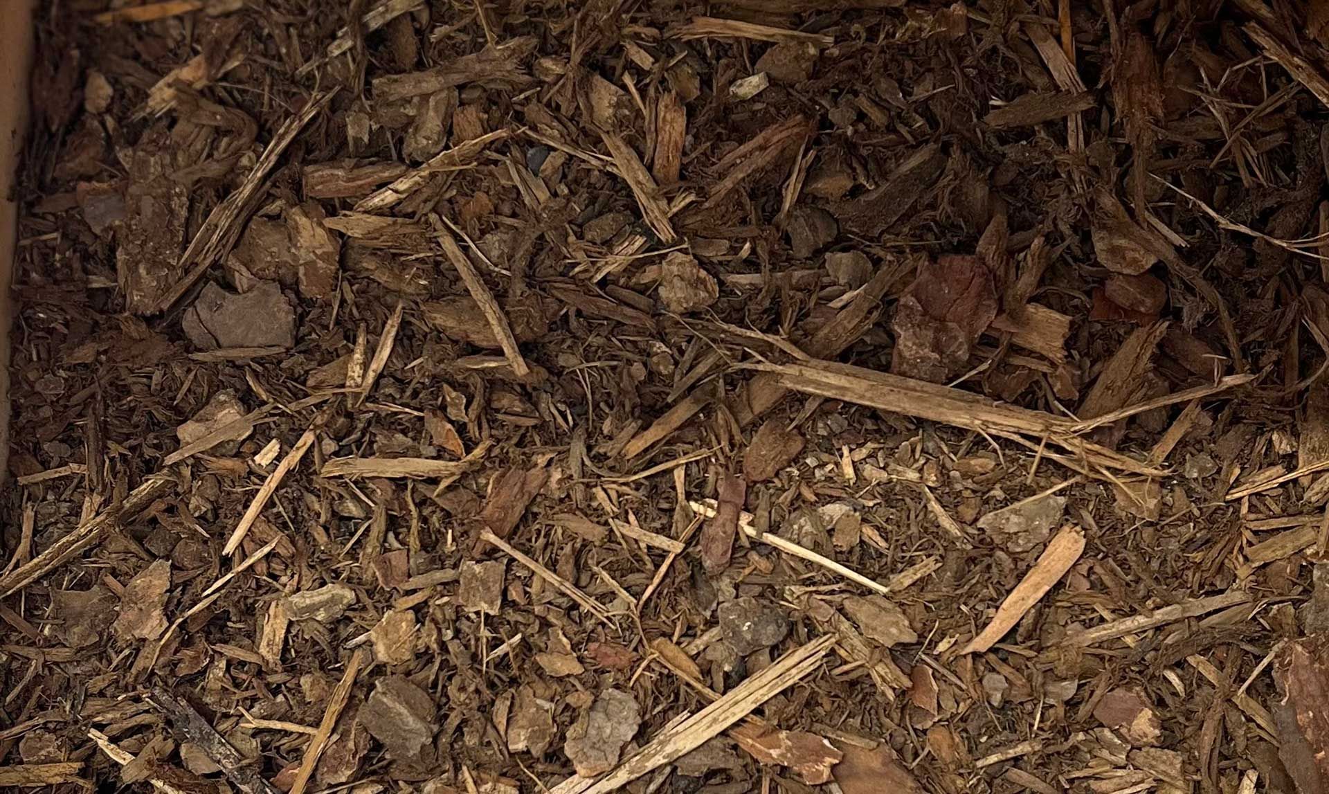 A pile of Hemlock and Fir chips sitting on top of a pile of dirt.