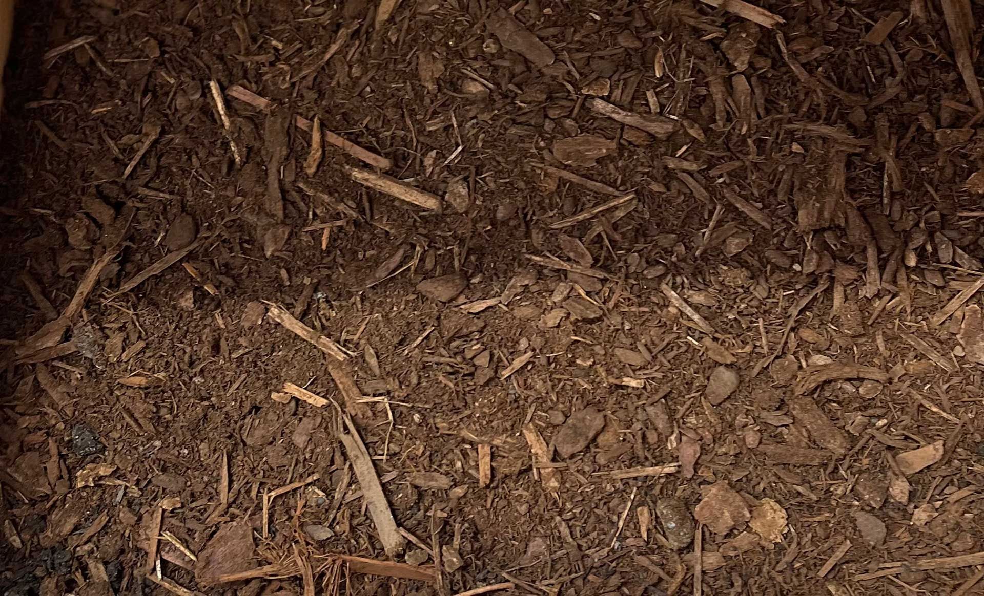 A pile of dirt and wood chips is sitting on the ground.