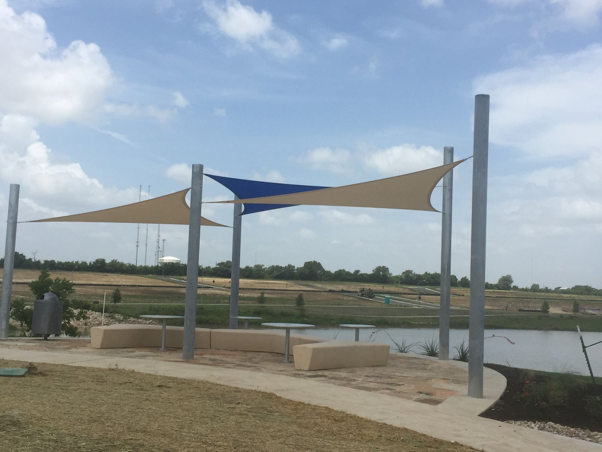 A row of shade sails overlooking a body of water