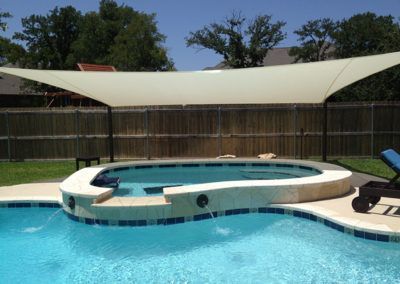 A large swimming pool with a white umbrella over it