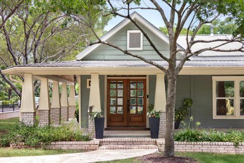 A bathroom with two sinks , two mirrors and a glass block wall.