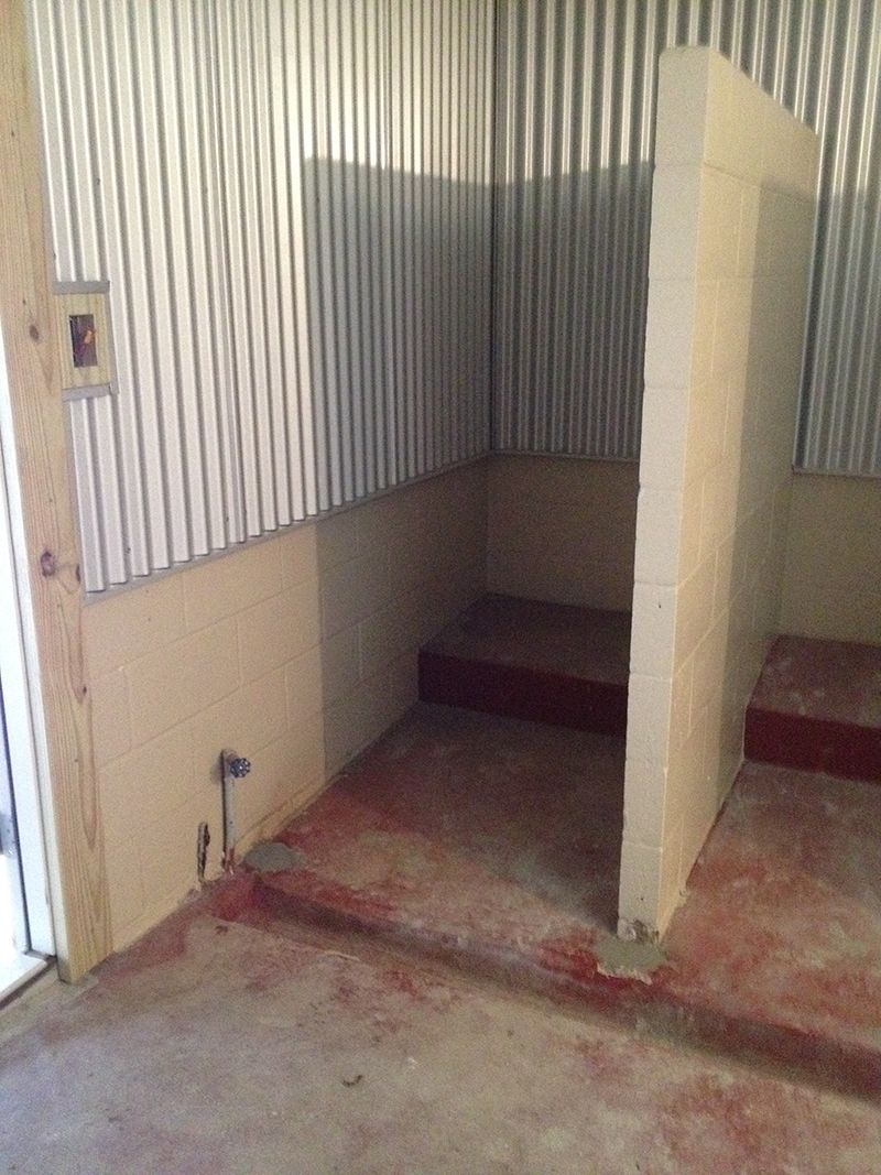 A room with a concrete floor and a metal wall.