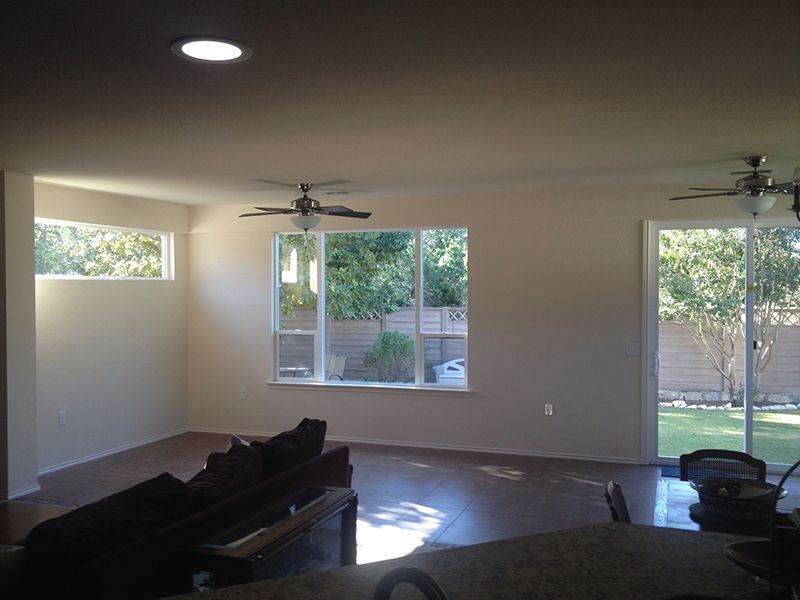 A living room with a sliding glass door and a ceiling fan