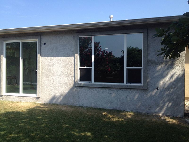 A house with a large window and sliding glass doors