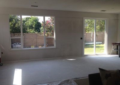 A living room with a lot of windows and a sliding glass door.