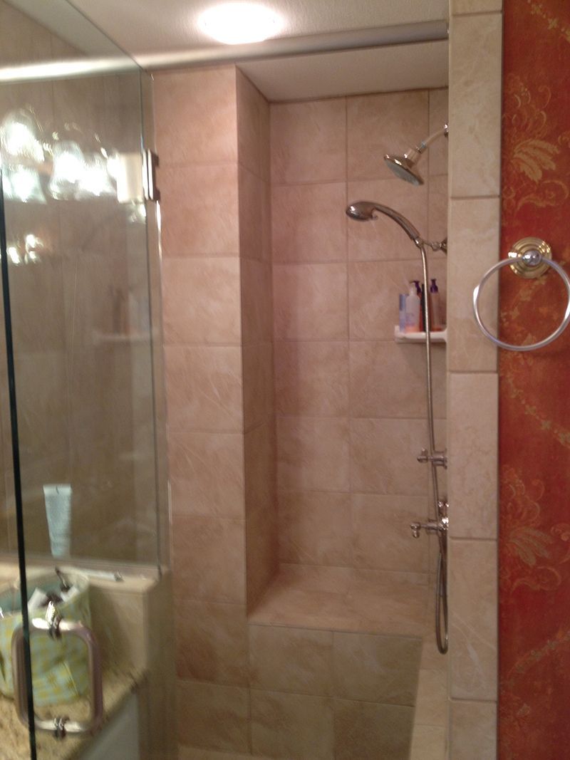 A bathroom with a walk in shower and a sink