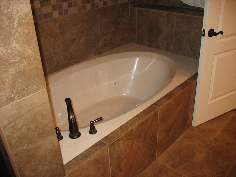 A bathtub in a bathroom next to a door