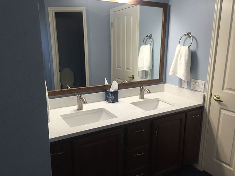 A bathroom with two sinks and a large mirror.
