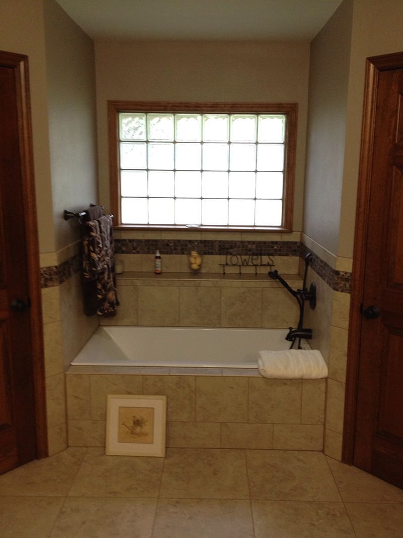 A bathroom with a bathtub and a window