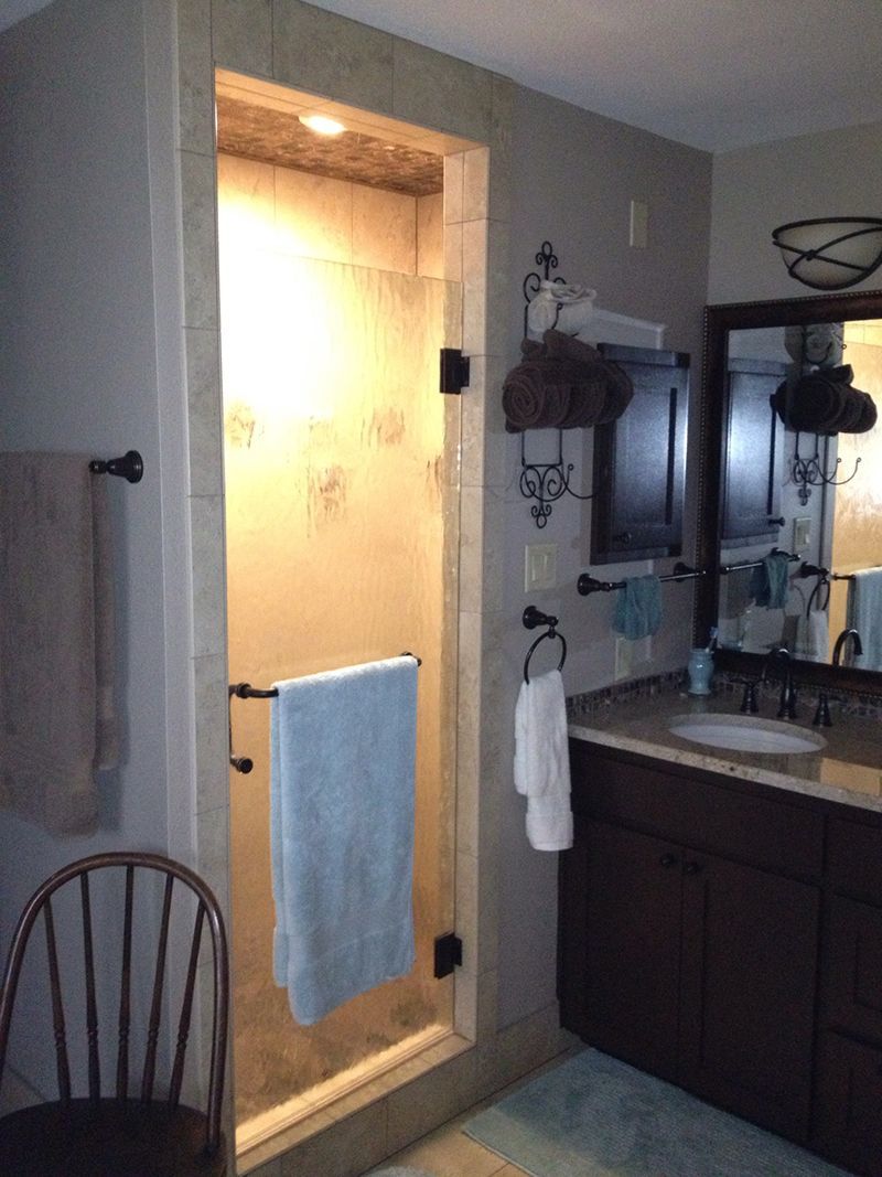 A bathroom with a walk in shower and a sink