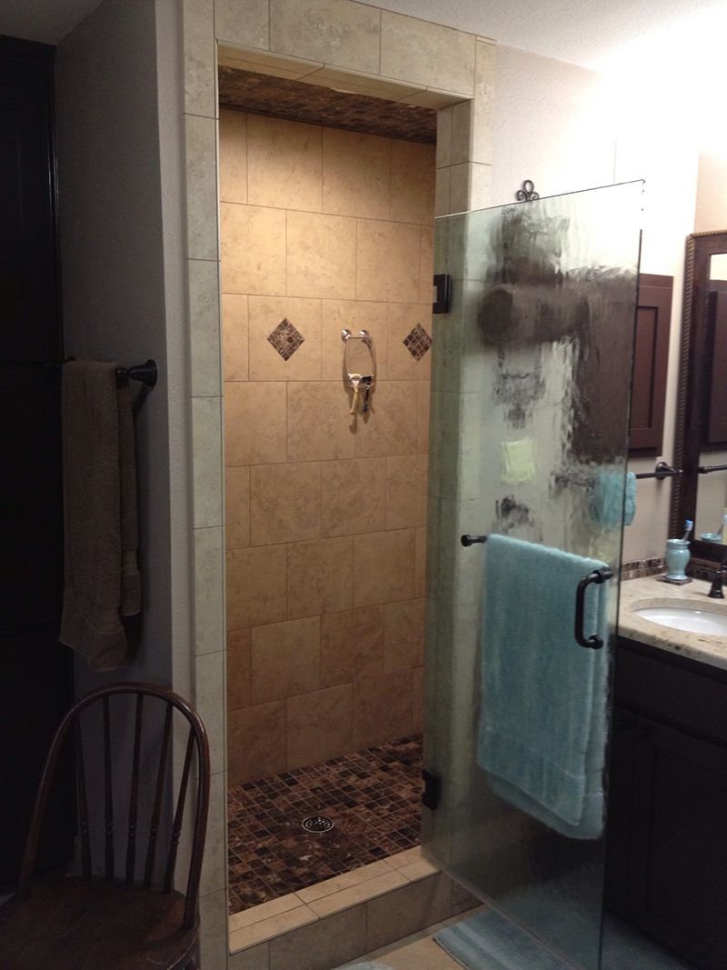 A bathroom with a walk in shower and a sink.