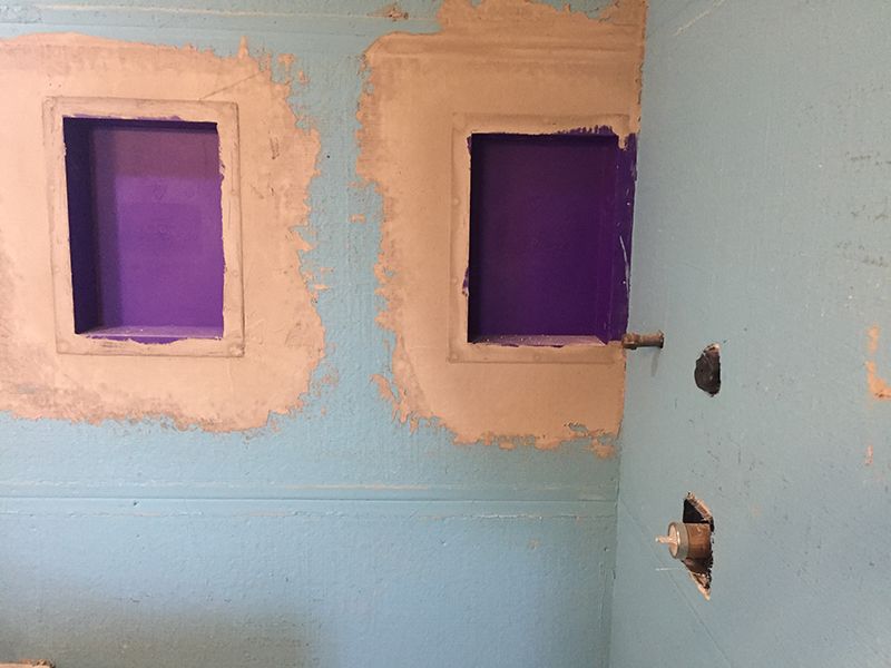 A bathroom with two purple squares in the wall.