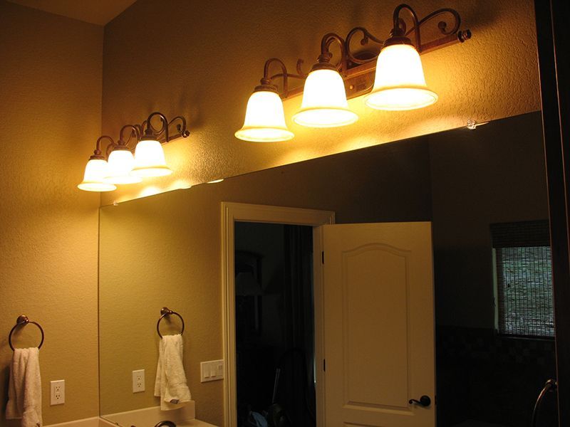 A bathroom with a mirror and lights on the wall