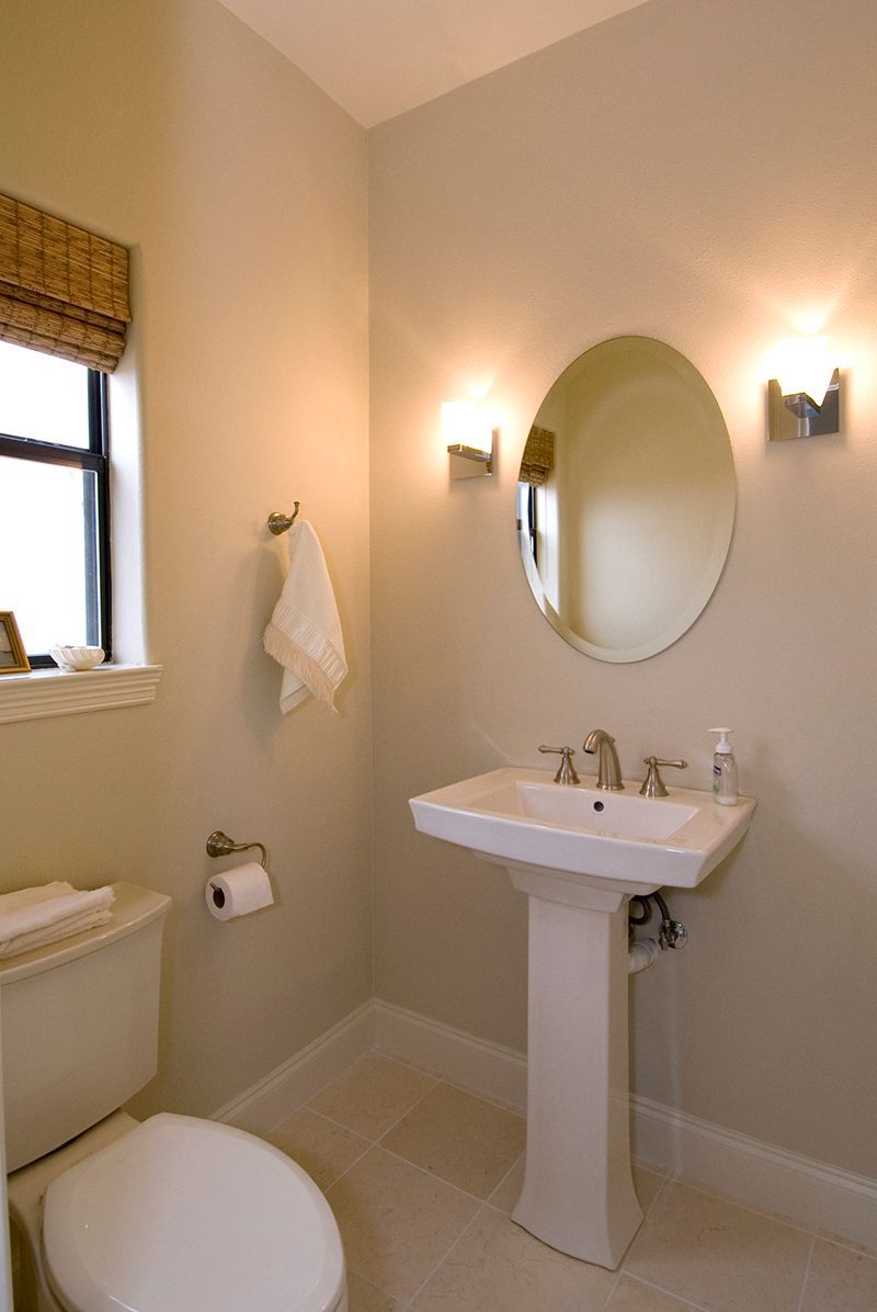 A bathroom with a toilet a sink and a mirror