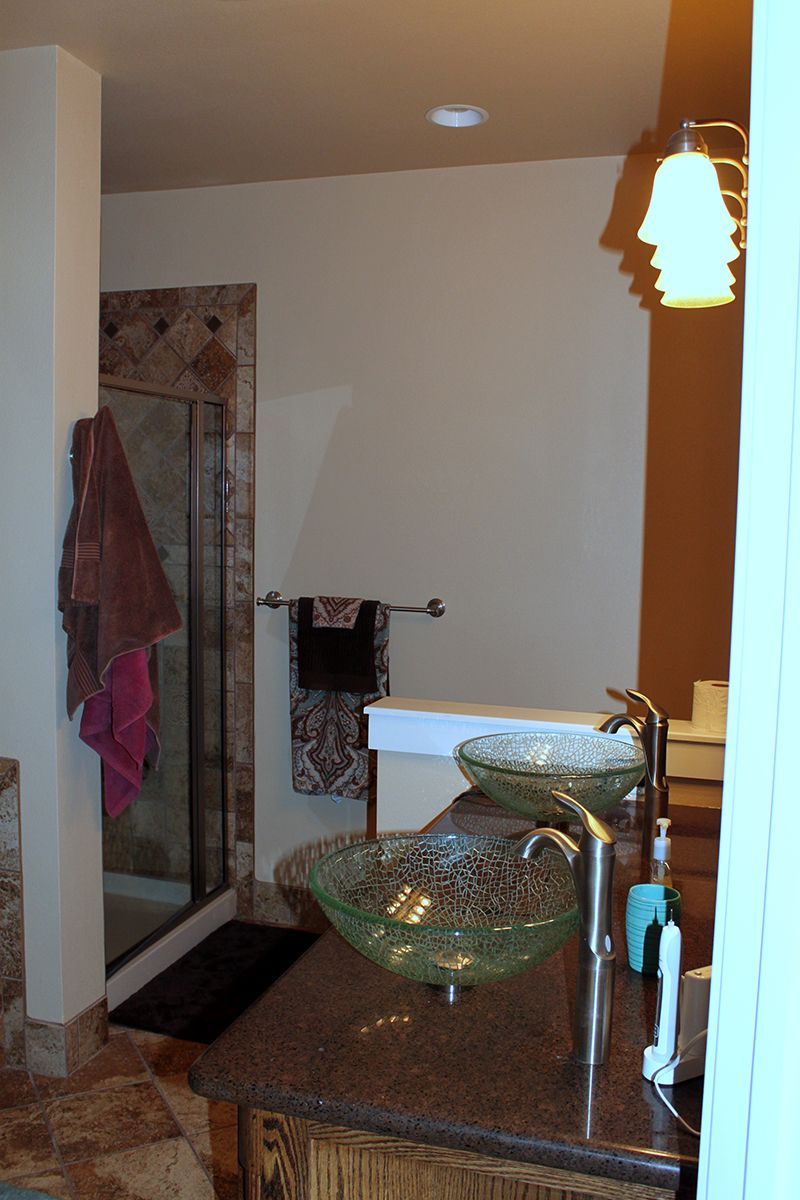 A bathroom with two sinks and a walk in shower