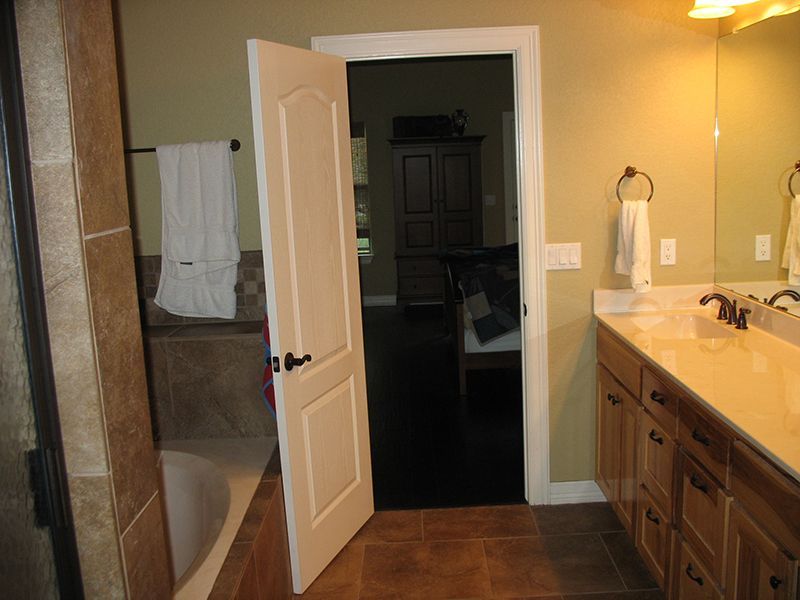 A bathroom with two sinks , a tub and a mirror.
