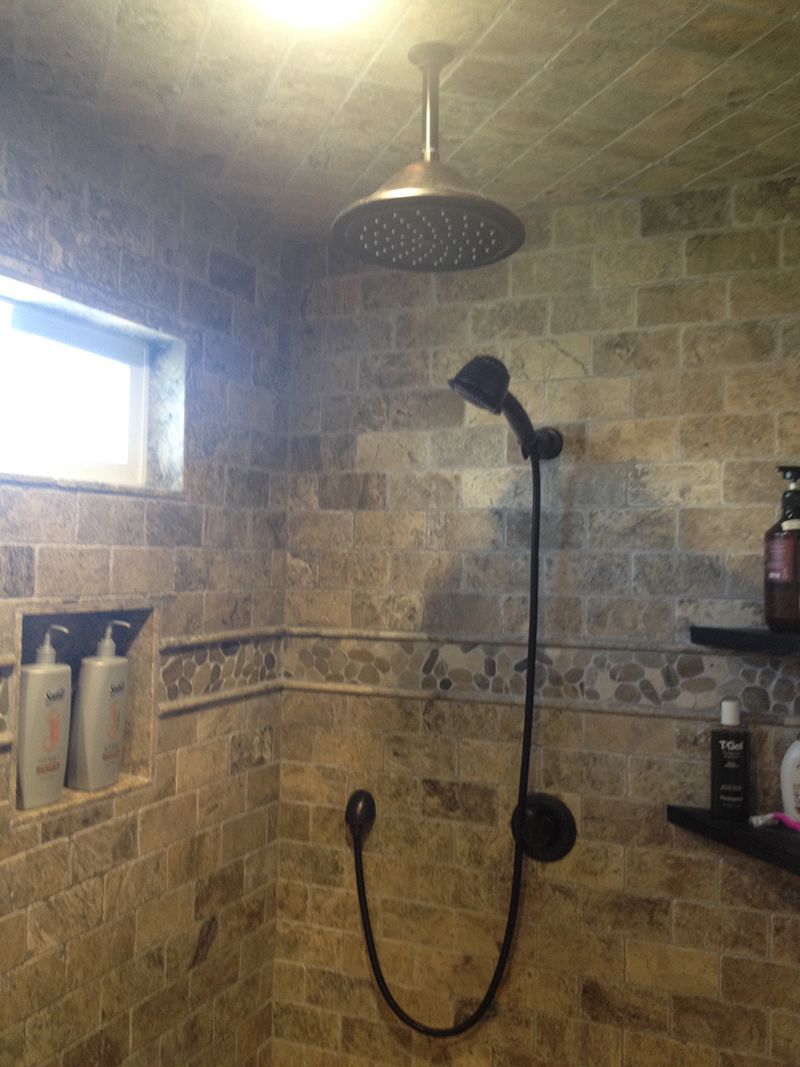 A bathroom with a shower head and a window.