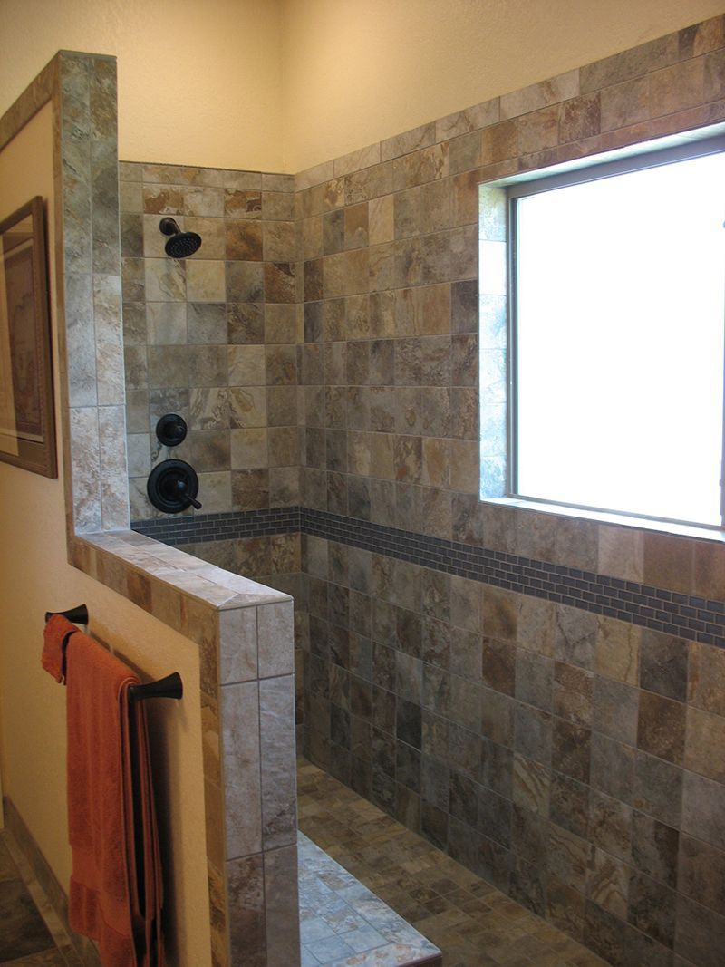 A bathroom with a walk in shower and a window