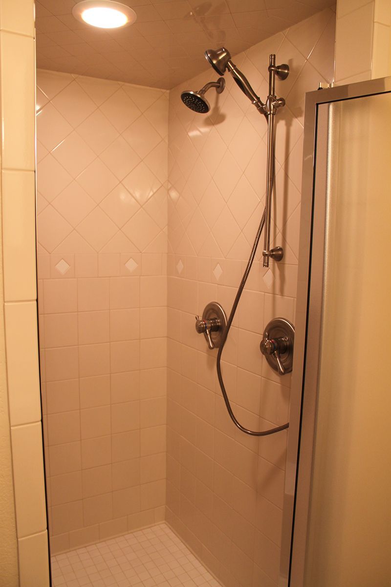 A shower with a sliding glass door and a shower head