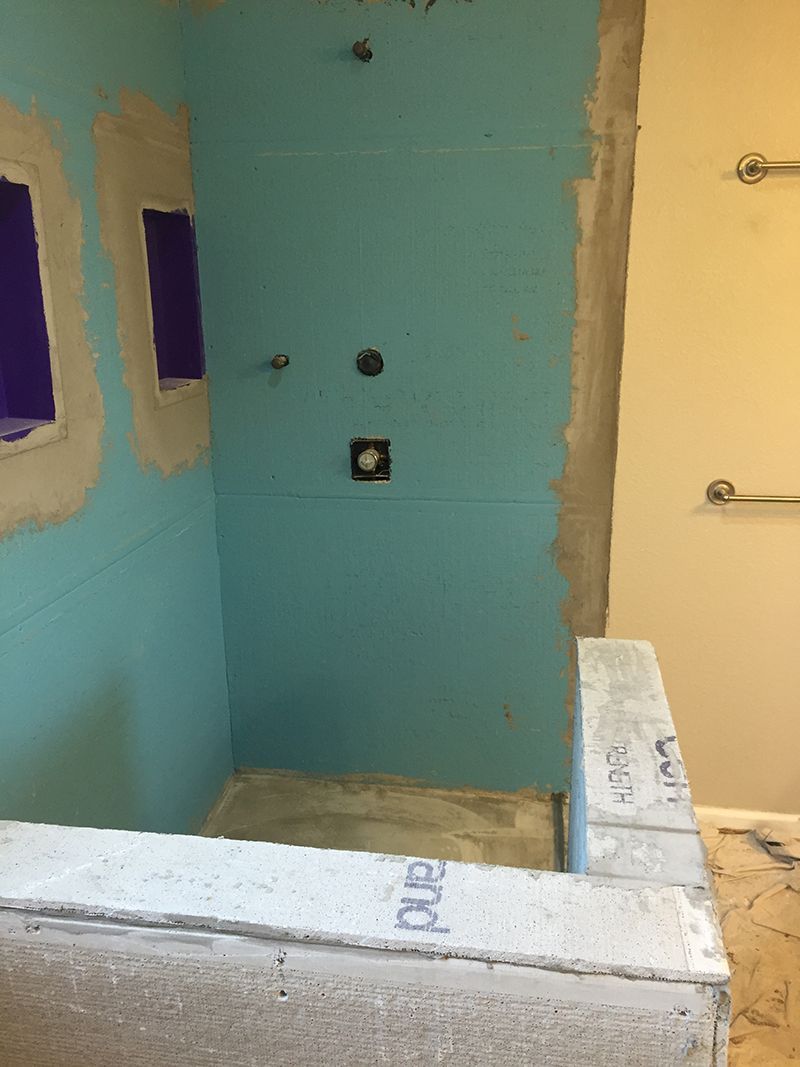 A shower is being built in a bathroom with blue walls.