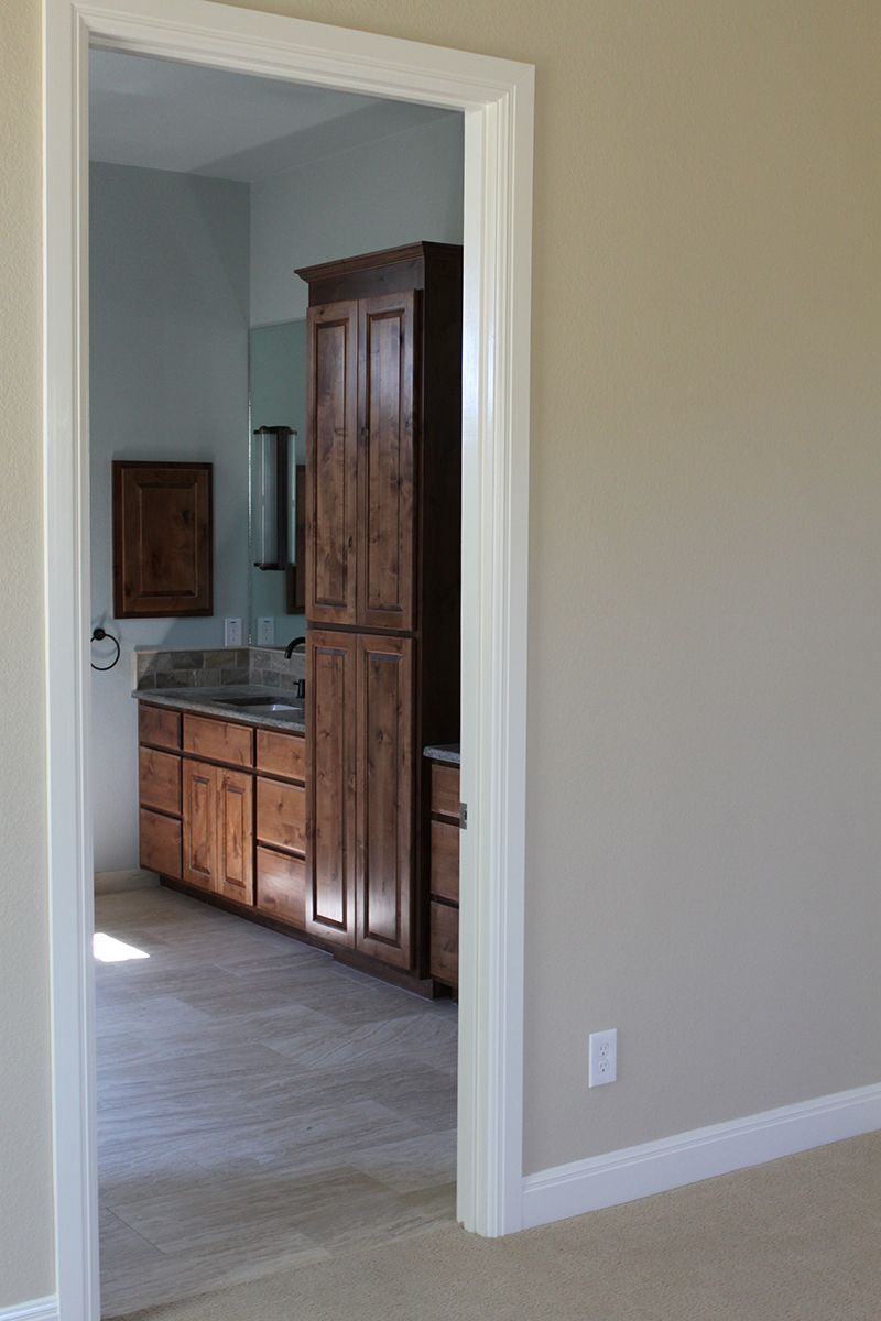 A bathroom with wooden cabinets and a sink