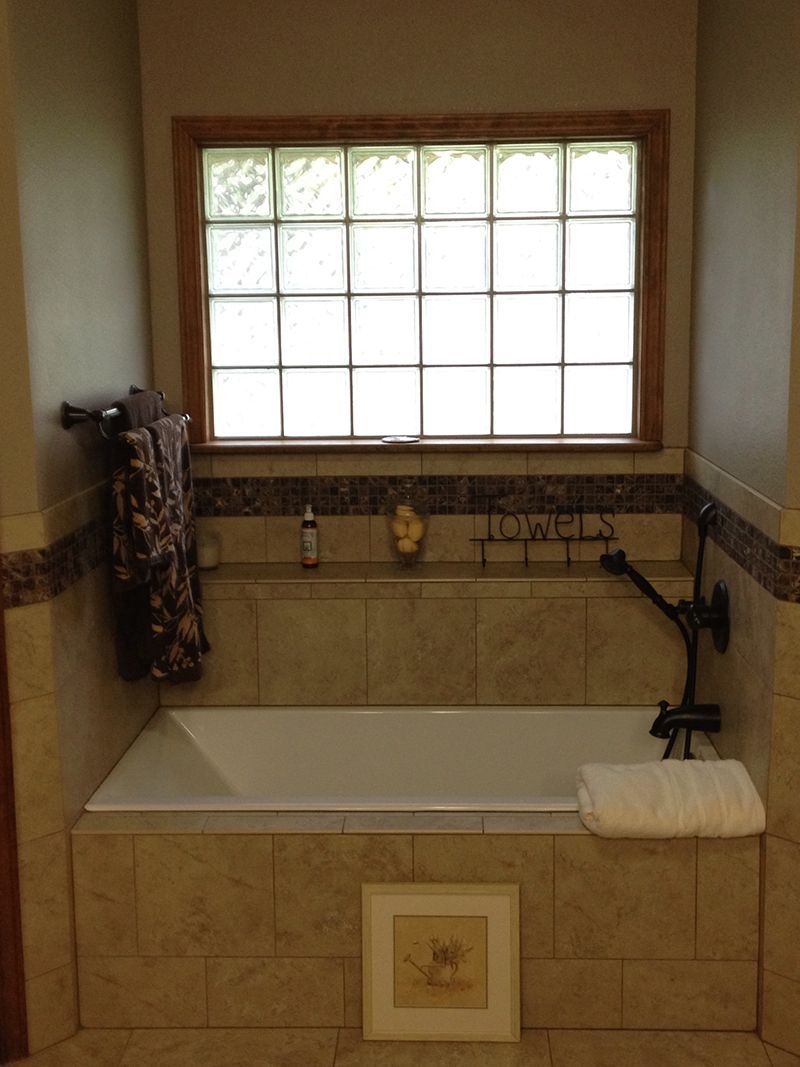 A bathroom with a bathtub and a window.