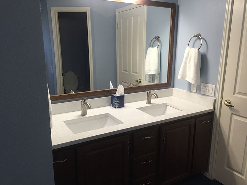 A bathroom with two sinks and a large mirror.