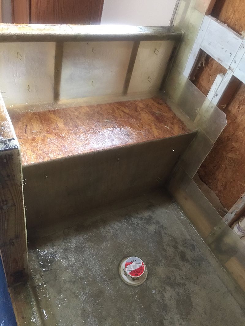A wooden bench is sitting on top of a concrete floor in a room.