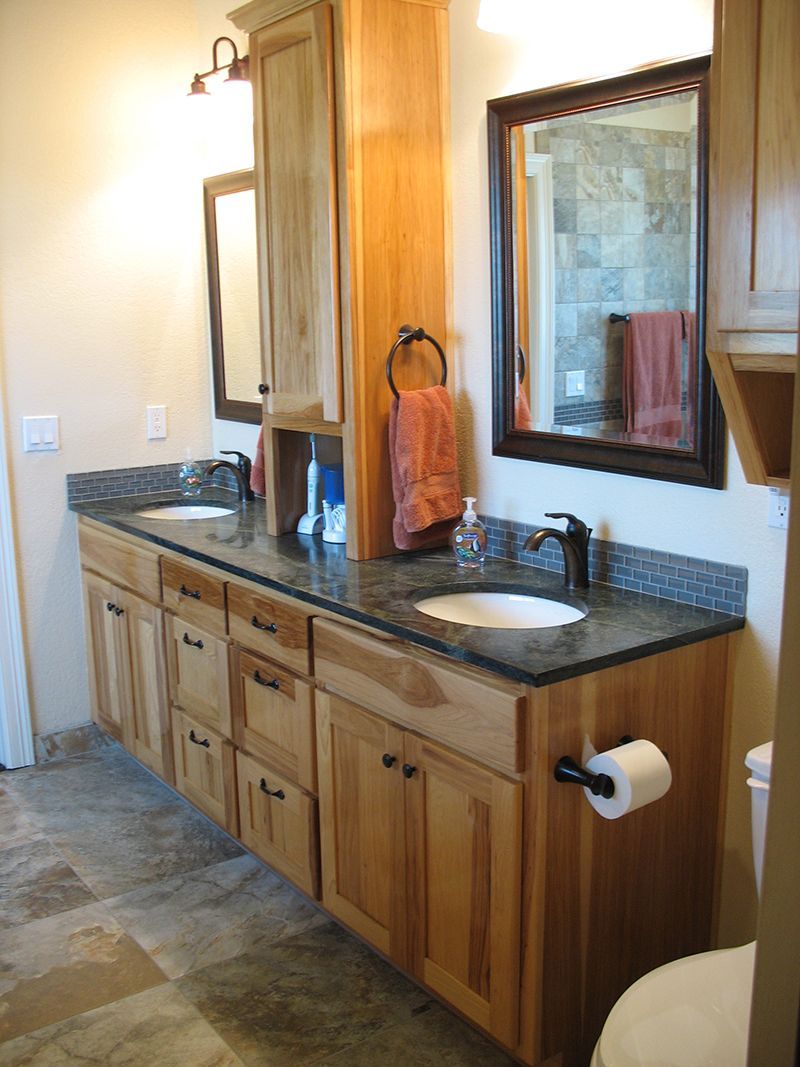 A bathroom with two sinks and a toilet
