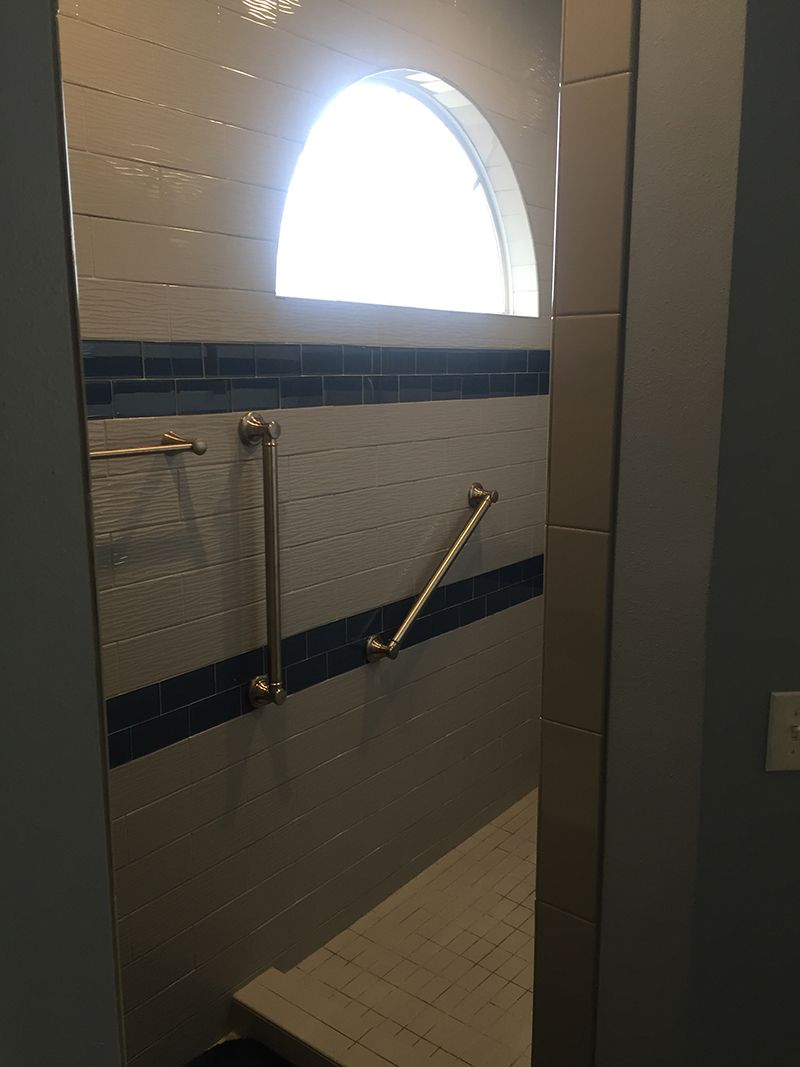 A bathroom with a walk in shower and a window.