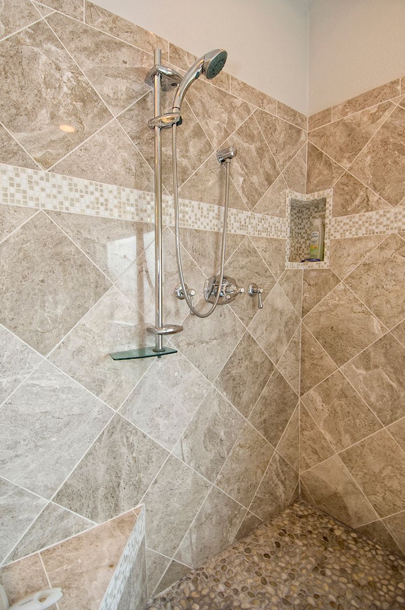 A bathroom with a walk in shower and a shower head.