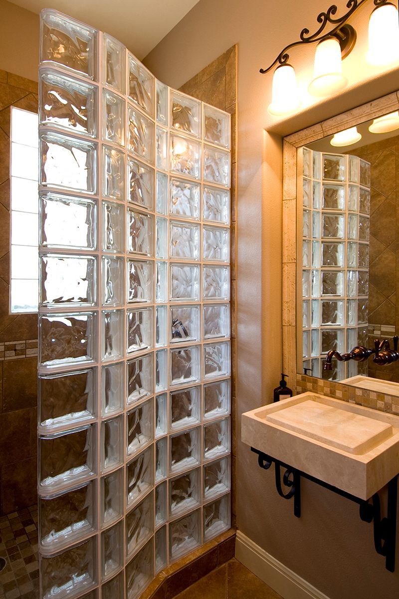 A bathroom with a glass block wall and a sink.