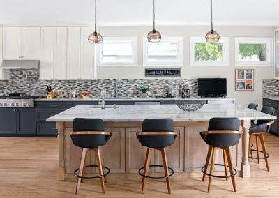 A kitchen with a large island and four bar stools.