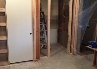 A room with a door and a ladder in it.