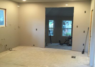 A room with a vacuum cleaner and a broom in it is being remodeled.