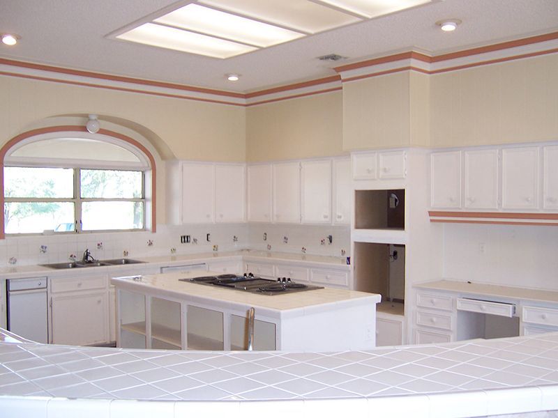 An empty kitchen with white cabinets and a large island