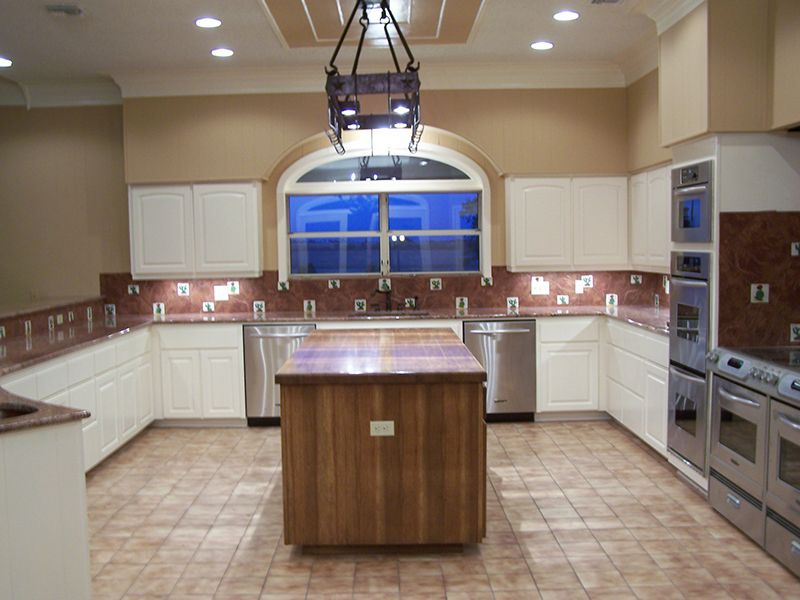 A kitchen with stainless steel appliances and a large wooden island