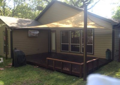 A house with a large deck and a canopy over it.