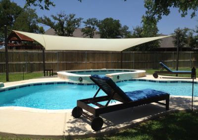 A swimming pool with a canopy over it and chairs around it.