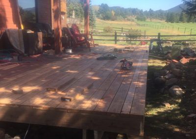 A wooden deck is being built in the backyard of a house.