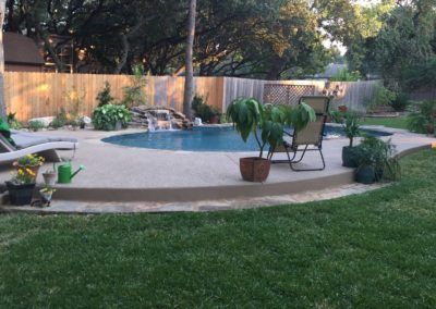 A backyard with a large swimming pool and chairs