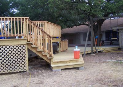 A wooden deck with stairs and a red cooler