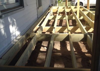 A wooden deck is being built on the side of a house