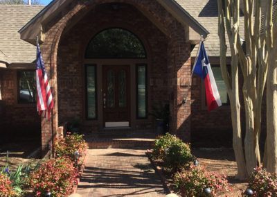 A brick house with two flags in front of it