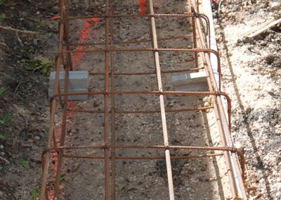 A rusty metal bar is sitting on top of a pile of dirt.